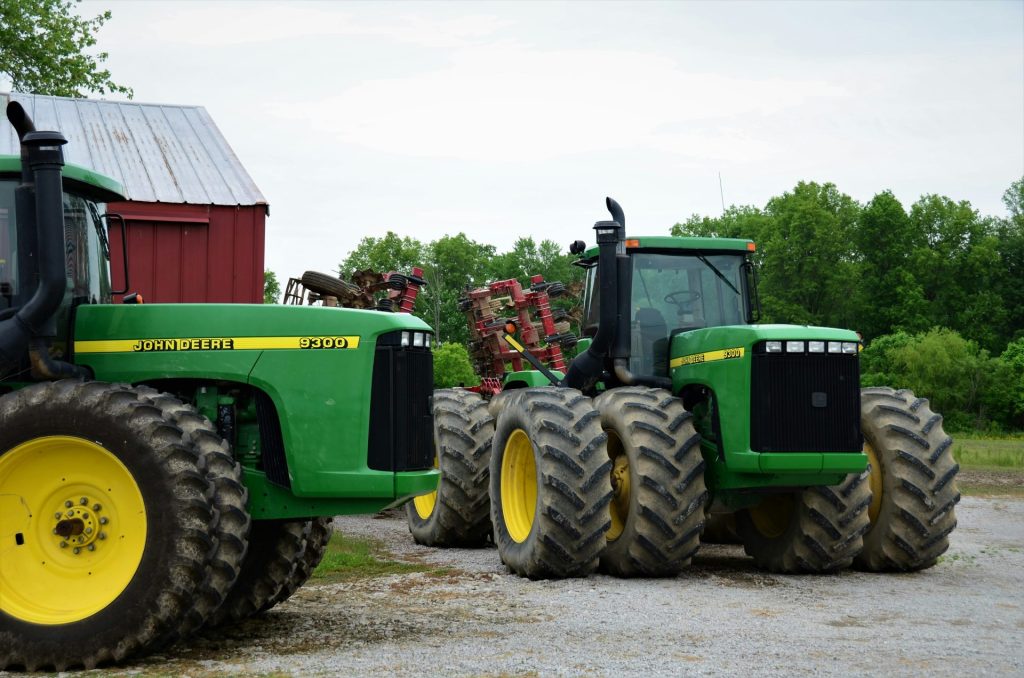 a couple of green tractors parked next to each other